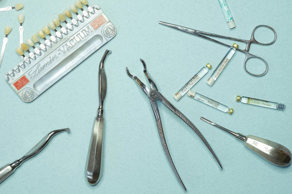 Overhead shot of various dental tools and materials arranged on a blue background.